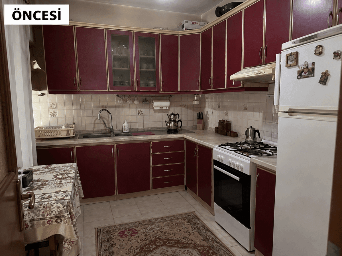 Mersin mutfak dolabı yenileme öncesi — bordo kırmızı ahşap kapaklar, bej fayans ve cam vitrinli üst dolaplar